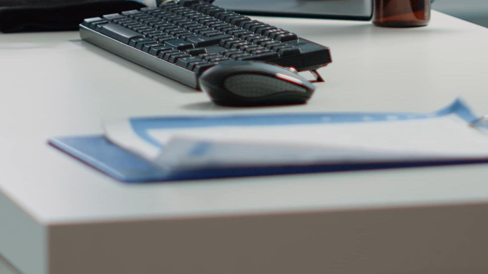 A doctor's office desk with a computer and medical instruments, no one present