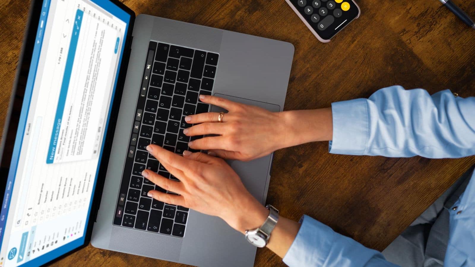 Overhead view of a woman typing at a laptop